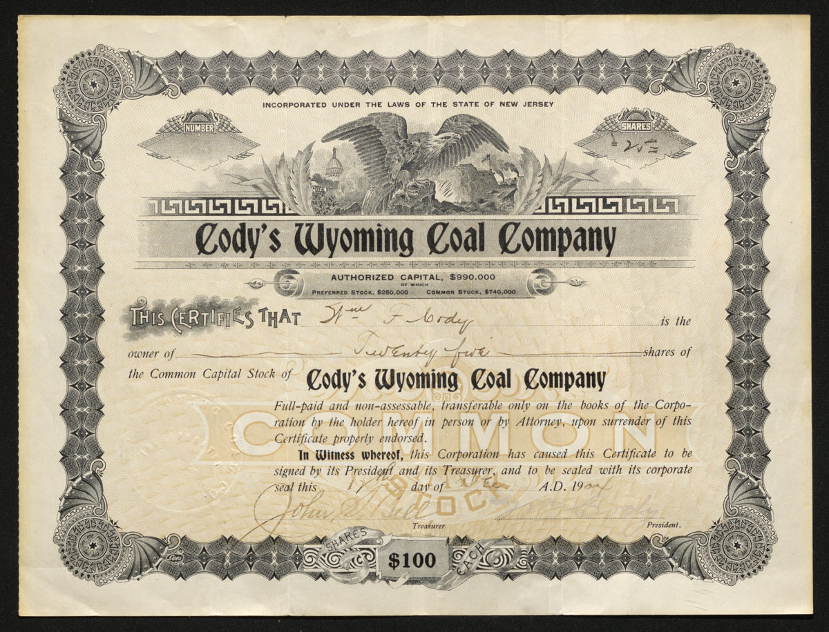 Certificate with black and yellow ink shows intricate bordering, lettering, a seal, signatures, and vignettes of an eagle, train, and coal mine